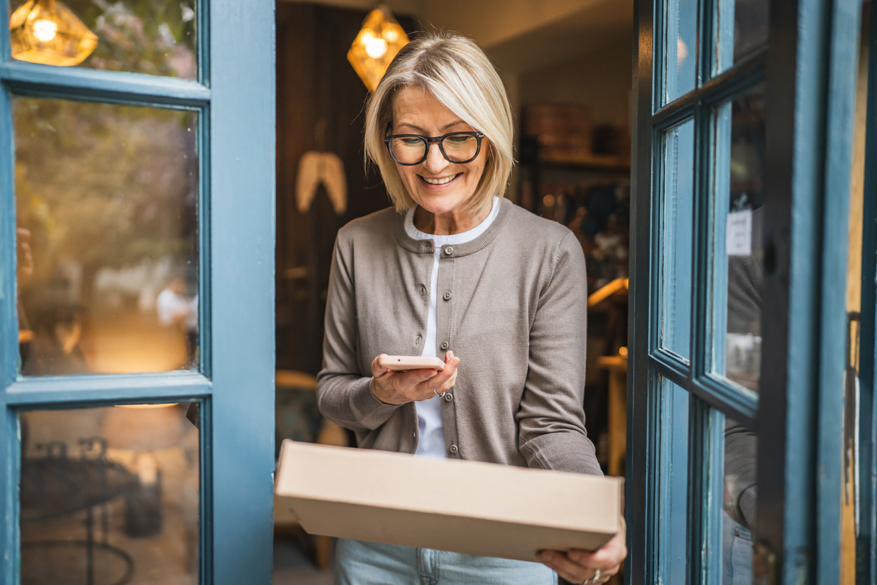 Image of woman checking phone for delivered parcel information