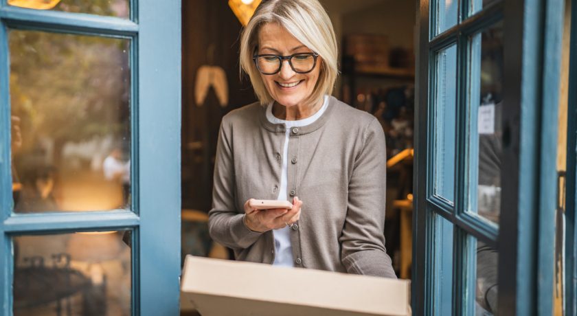 woman entrepreneur scan package with cellphone at the store entrance